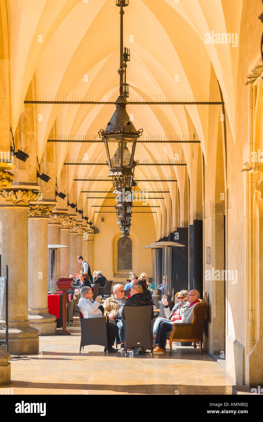 Krakow Cloth Hall, view of tourists drinking coffee at a cafe inside the colonnade of the 16th Century Cloth Hall - Sukiennice - in Krakow, Poland. Stock Photo