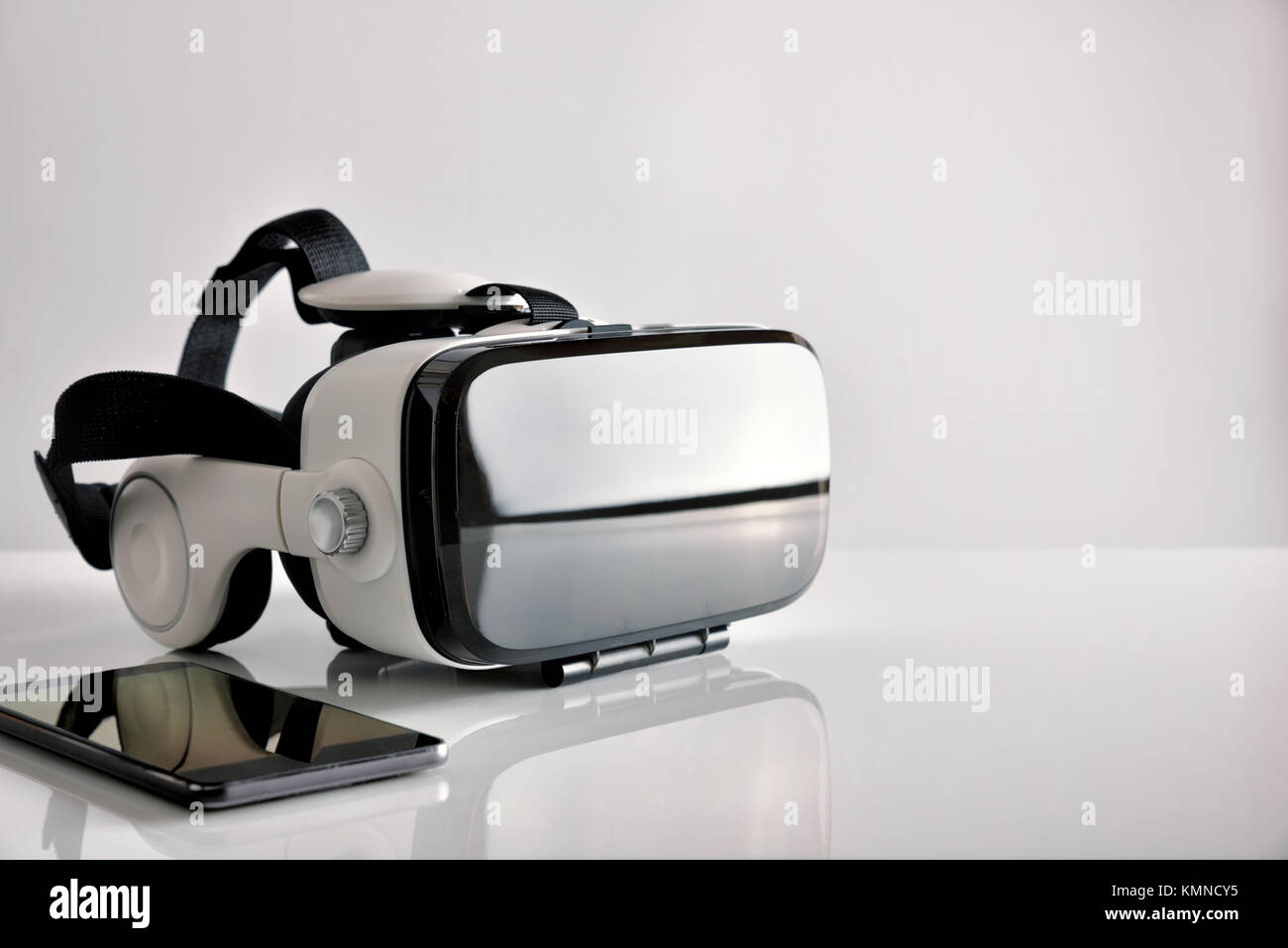 Black and white virtual reality glasses with smartphone on white ...