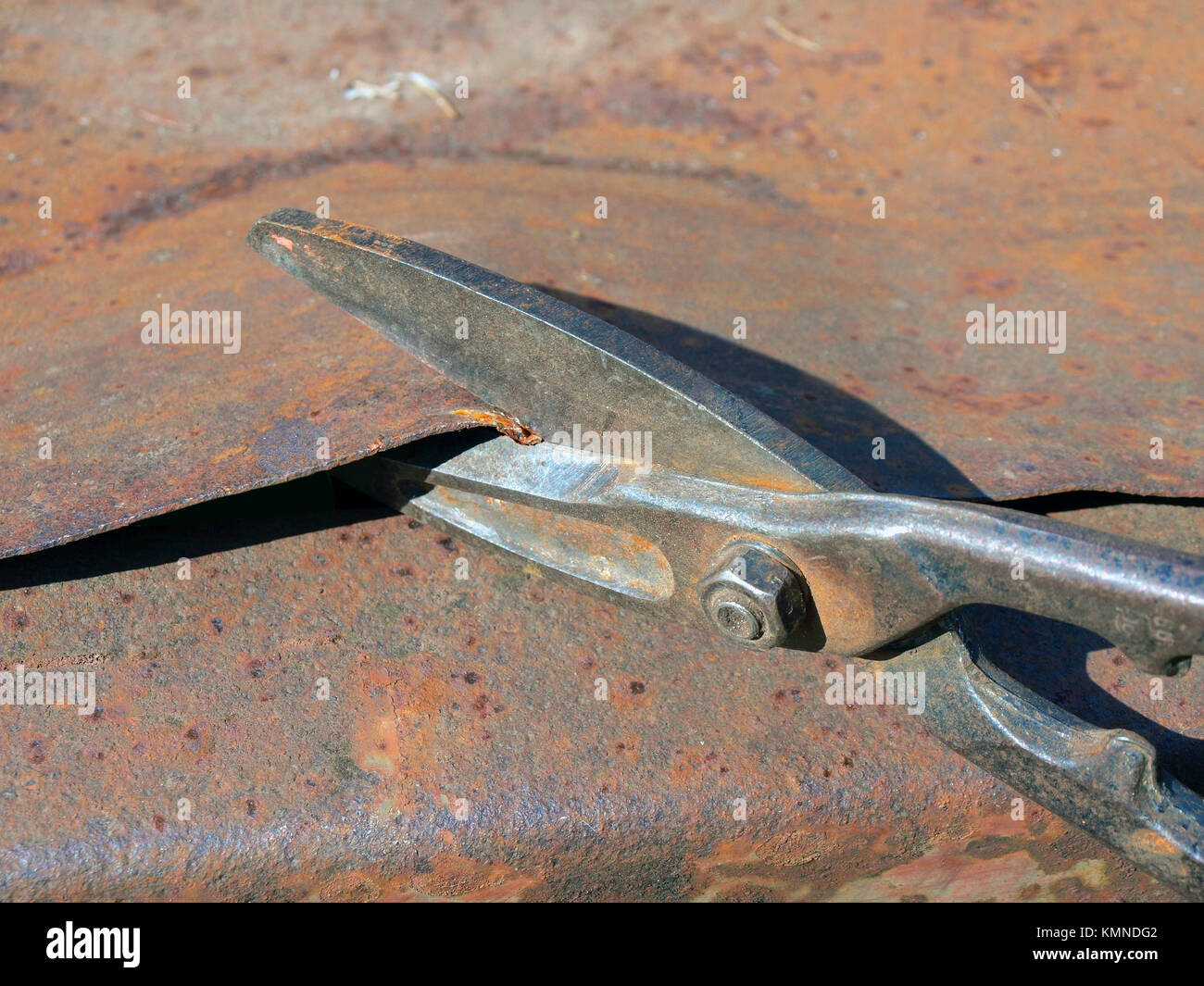 Metal scissors cutting rusty iron sheet close up Stock Photo Alamy