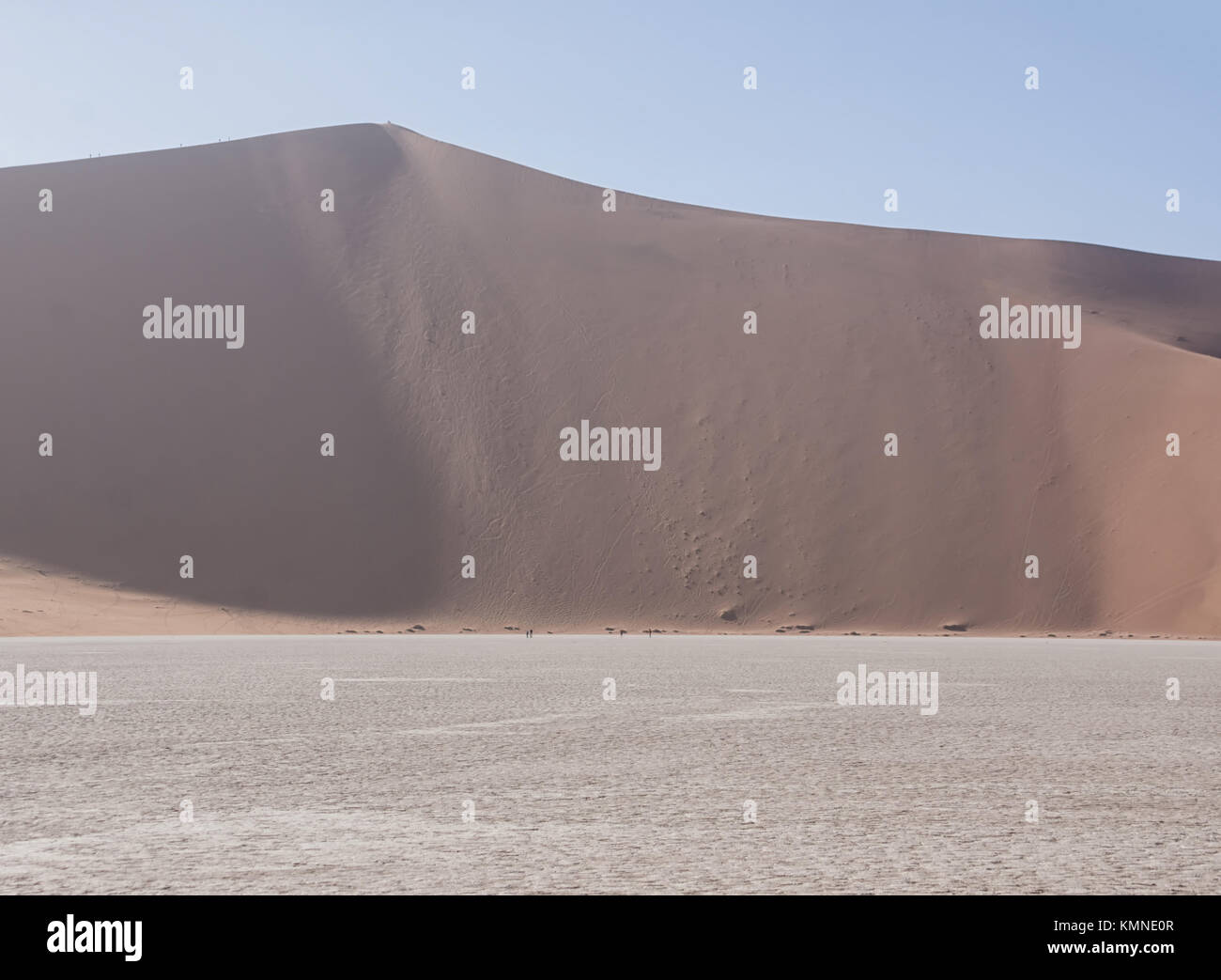 Tourists climbing a dune in the Namibian desert at Dead Vlei Stock ...