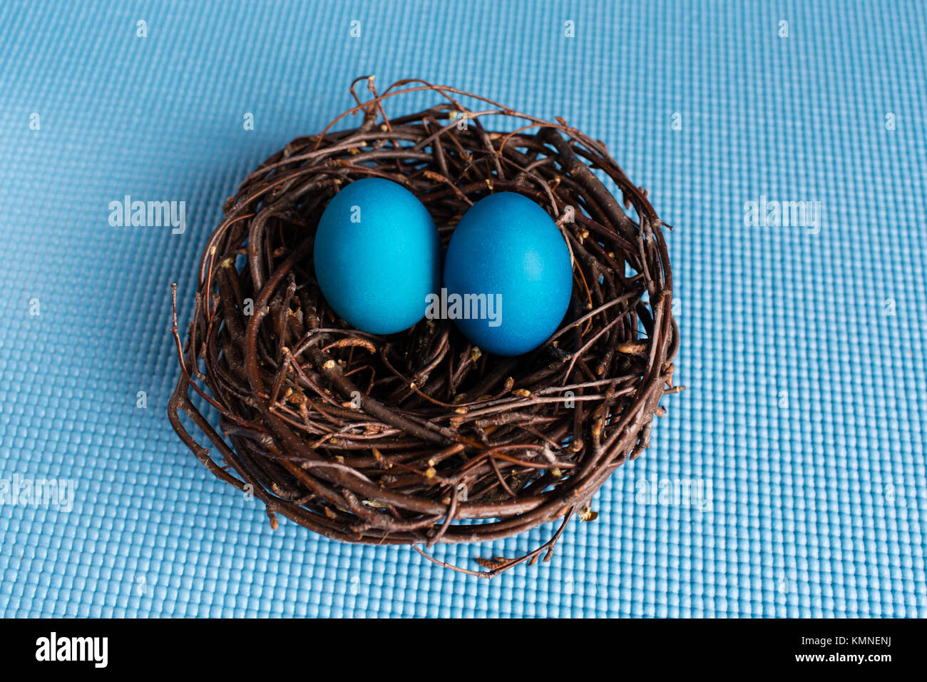 Easter eggs in the nest on blue background Stock Photo - Alamy