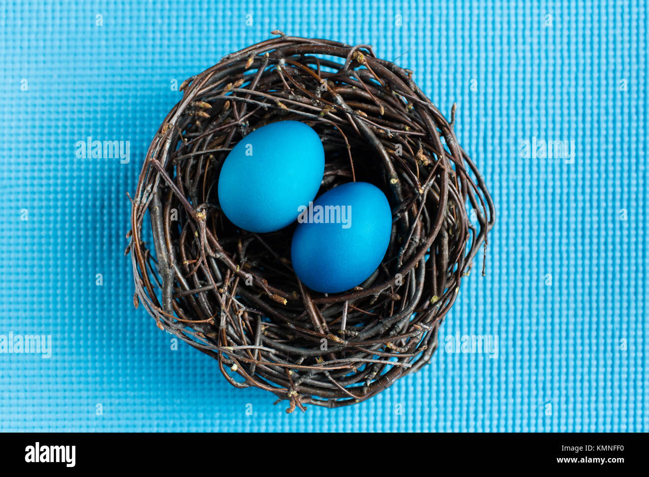 Easter eggs in the nest on blue background Stock Photo - Alamy