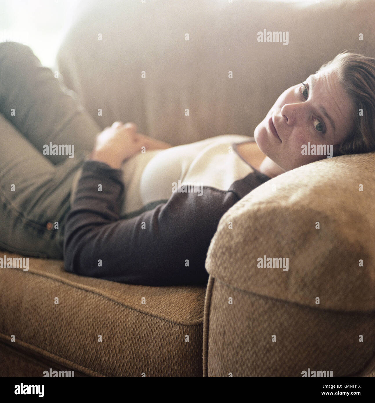 Portrait of 34 year old woman laying on couch Stock Photo Alamy