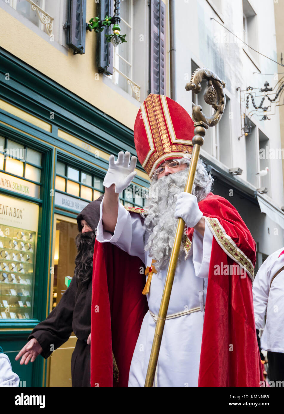 Lucerne, Switzerland - 2 Dec 2017: St. Nicholas, followed by his servant 'Knecht Ruprecht'  is waving to spectators during a Christmas parade. Stock Photo
