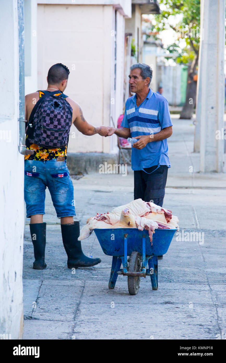 Man selling pork from a wheelbarrow in Cienfuegos, Cuba Stock Photo