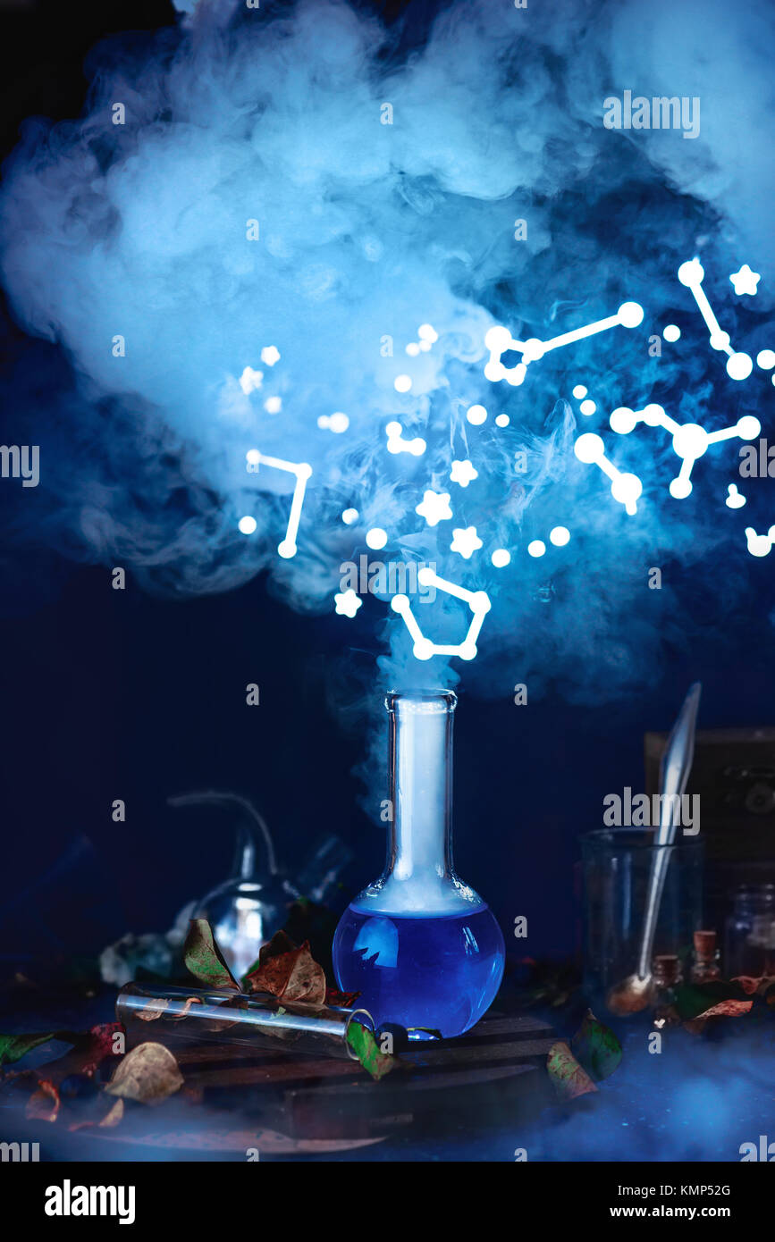 Potion bottle with steam and constellations. Still life with magical equipment and starry sky. Astronomer workplace Stock Photo