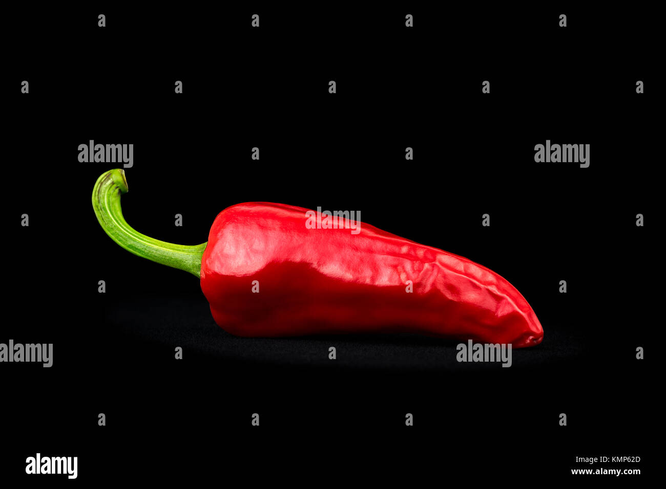 An Espelette chilli pepper (capsicum annuum) photographed on a black background in the studio. Red chili. Stock Photo