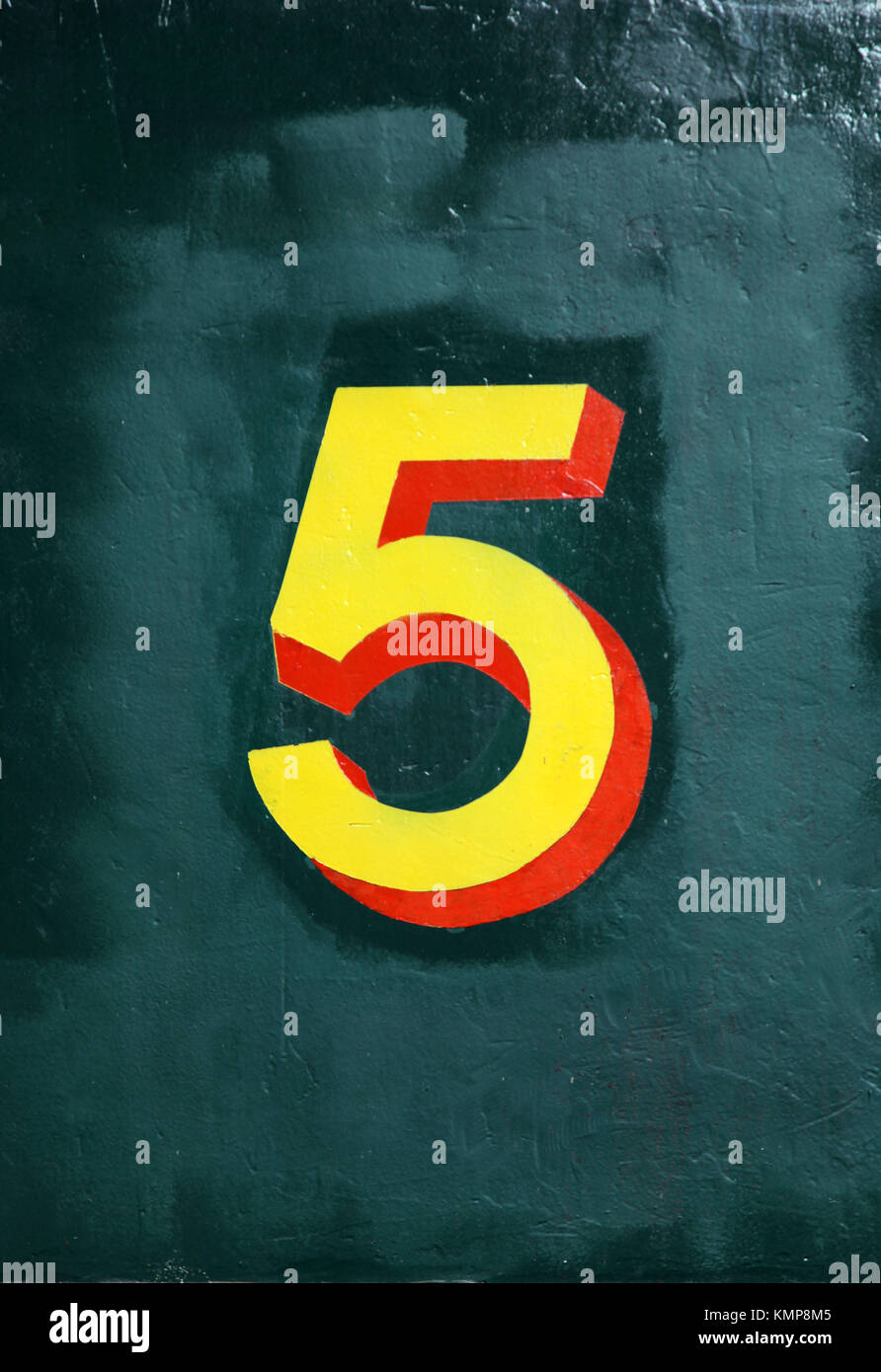 Number 1 or 5 painted on a green blue wall in a vintage style Stock Photo