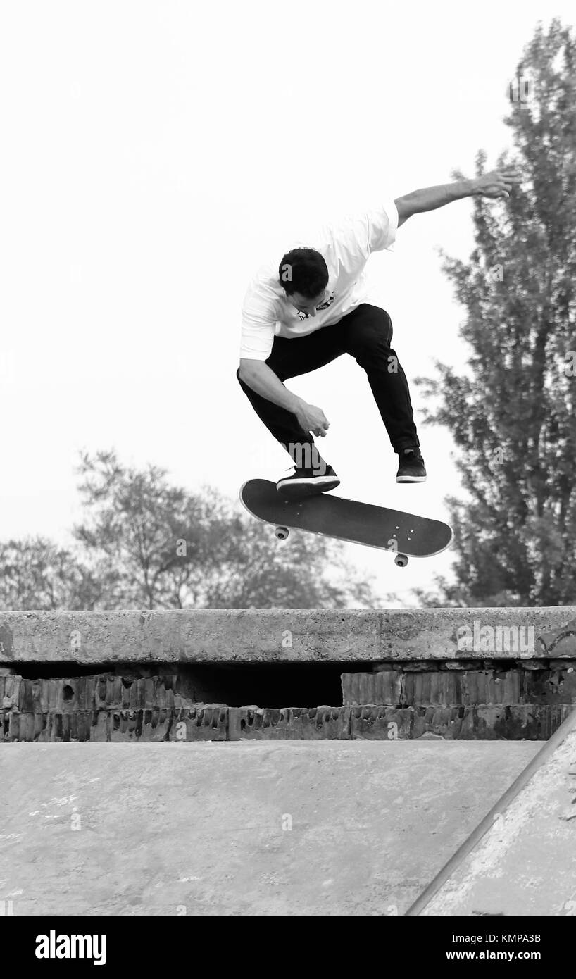 a guy make a jump and backside kickflip with the skateboard. Stock Photo