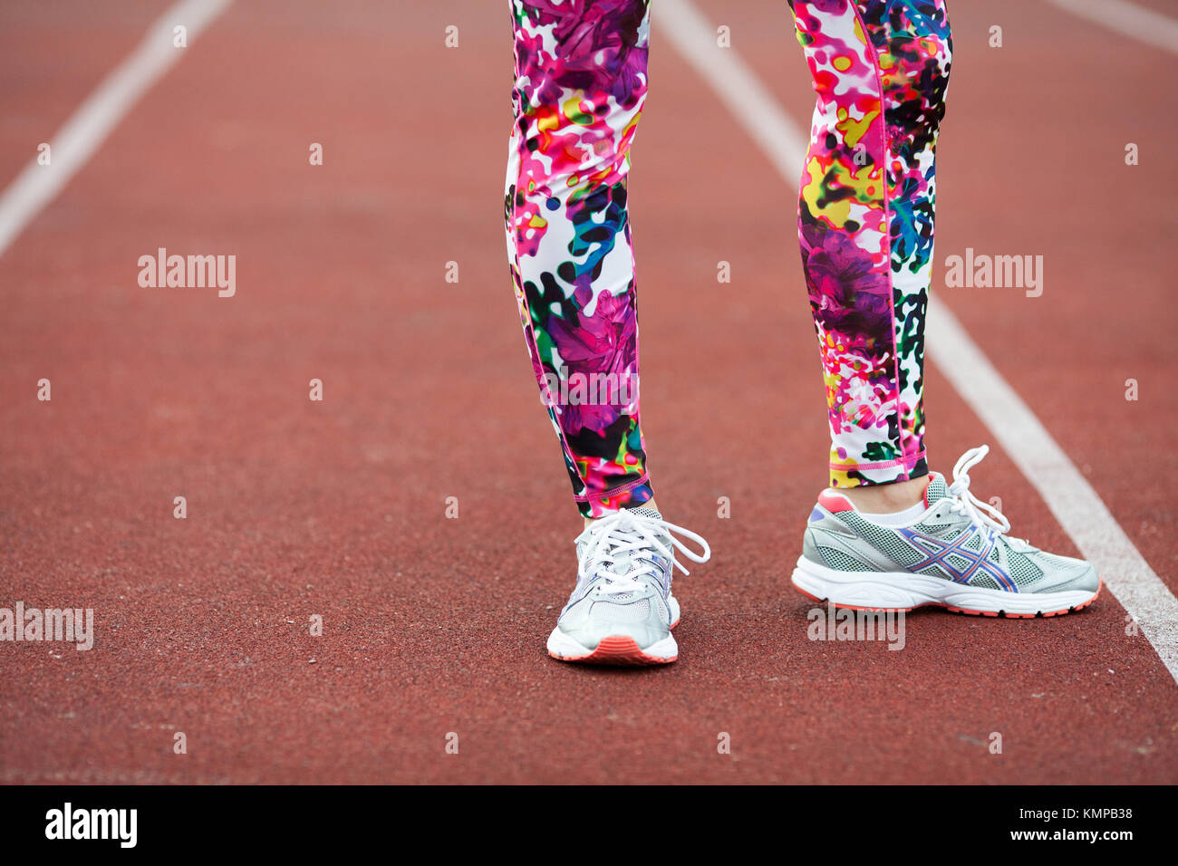 Legs sports girl in bright tights and grey sneakers on the Jogging path ...