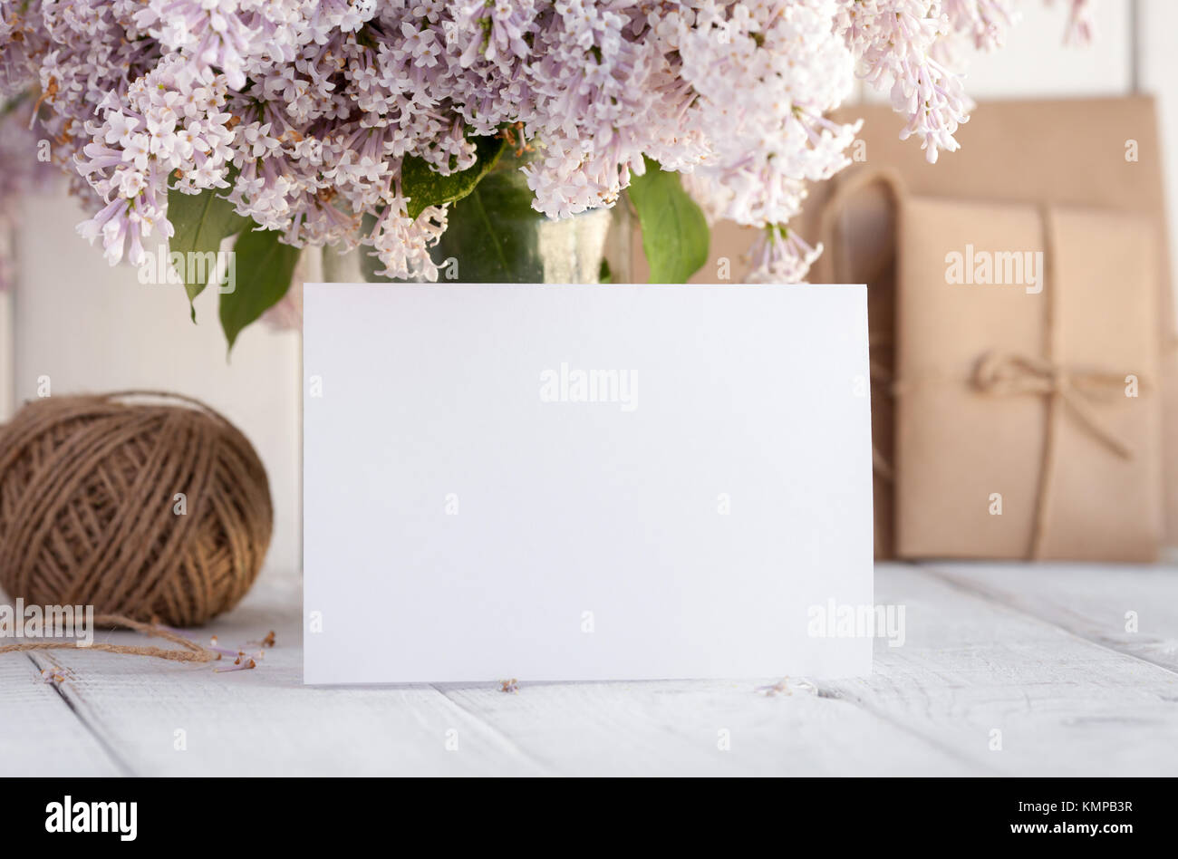 Blank white greeting card with lilac flowers bouquet and envelope on ...