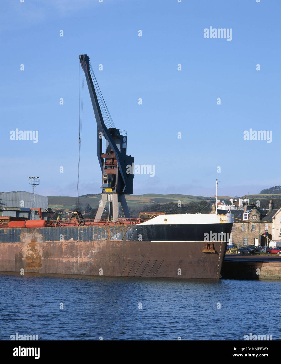Crane unloading bulk cargo from barge. Burntisland, Scotland Stock Photo