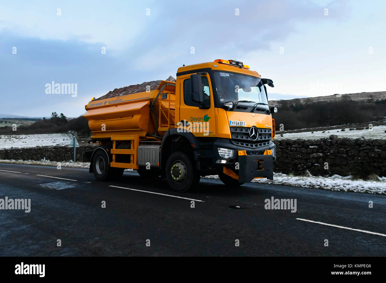 Princetown, Dartmoor, UK.  8th December 2017.  UK Weather.  A Devon County Council gritting lorry on a snow flanked B3357 near Princetown in the Dartmoor National Park in Devon on a cold wintery afternoon spreading grit ahead of a forecast night of ice and snow showers.  Picture Credit: Graham Hunt/Alamy Live News Stock Photo