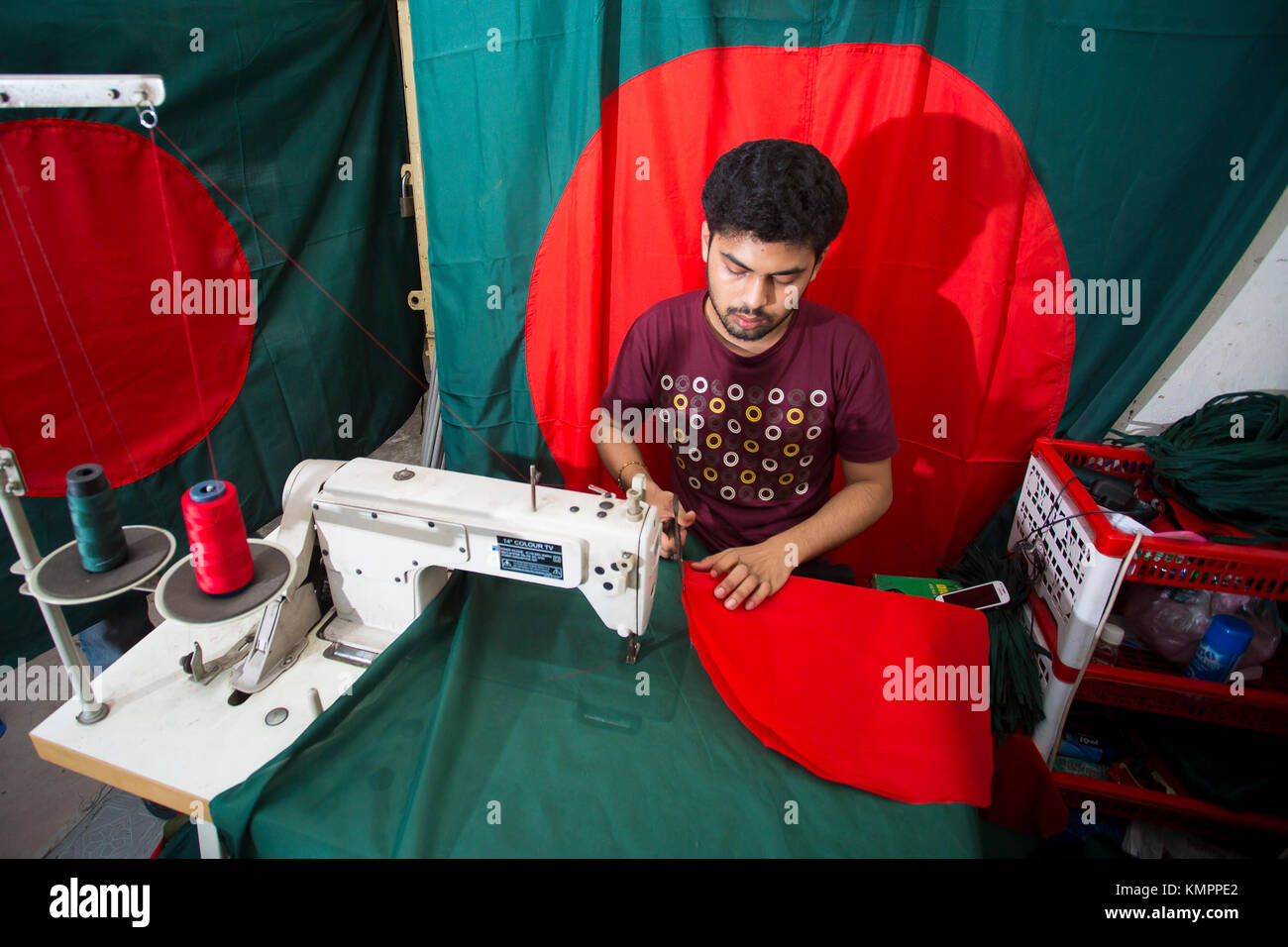 Dhaka, Bangladesh. 09th Dec, 2017. Victory day is a national holiday in Bangladesh celebrated on December 16 to commemorate the victory of the Allied forces High Command over the Pakistani forces in the Bangladesh Liberation War in 1971. A young tailor sewing cloth and making Bangladeshi national flags for selling Upcoming 16 December events. Credit: Jahangir Alam Onuchcha/Alamy Live News Stock Photo