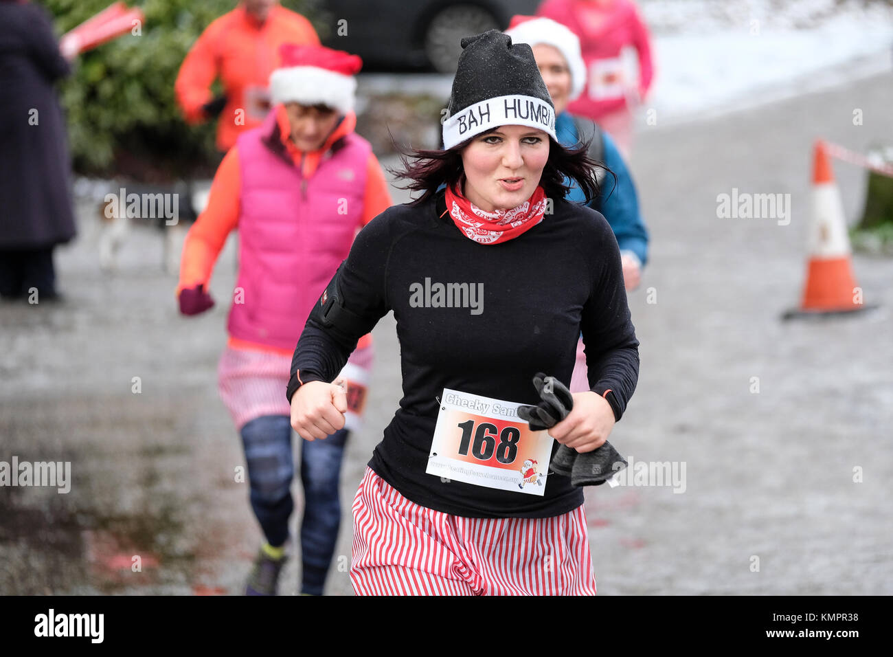 Young woman with Bah Humbug hat running in Santa Dash in freezing conditions to raise money for bowel cancer charity Stock Photo