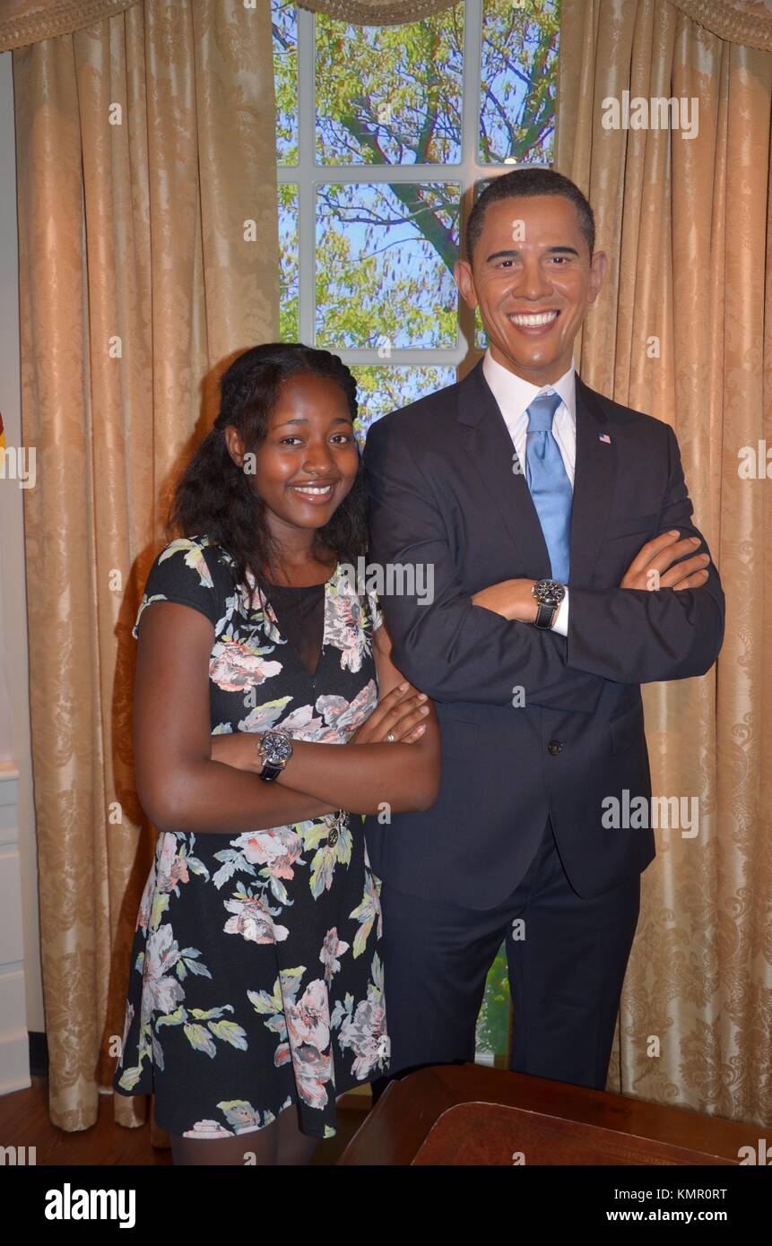 Afro-Caribbean woman posing next to Obama wax figure at Madame Tussauds, International Drive, Orlando, Florida, USA Stock Photo