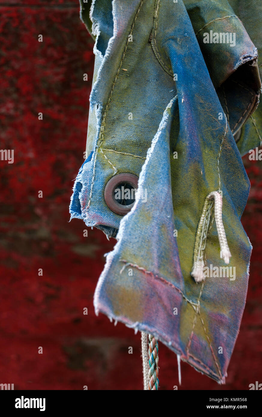 Close up image of an old torn jacket named to the hull of a rusty boat