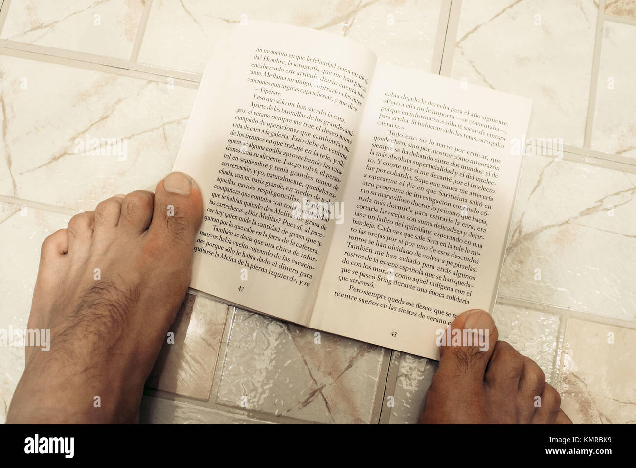Feet holding book Stock Photo Alamy