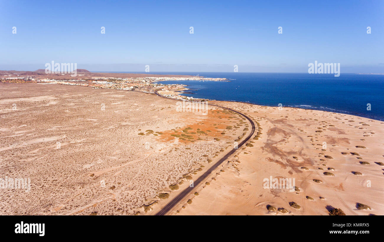 Aerial view of road going through white sand beach, dunes towards tourist resort of Corralejo, , Fuerteventura, Canary Islands, Spain . Stock Photo