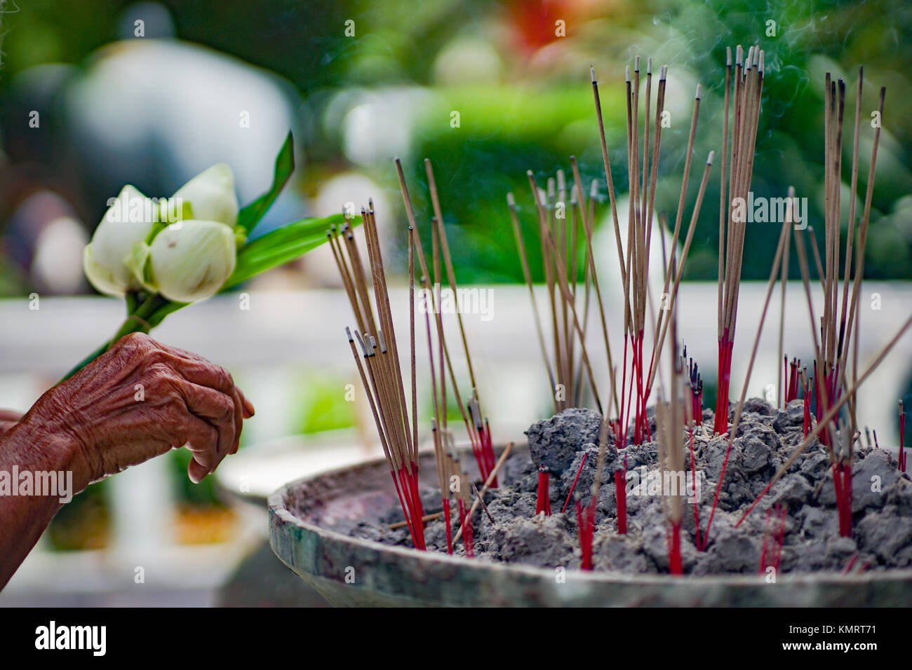 Put incense in incense pot Stock Photo - Alamy