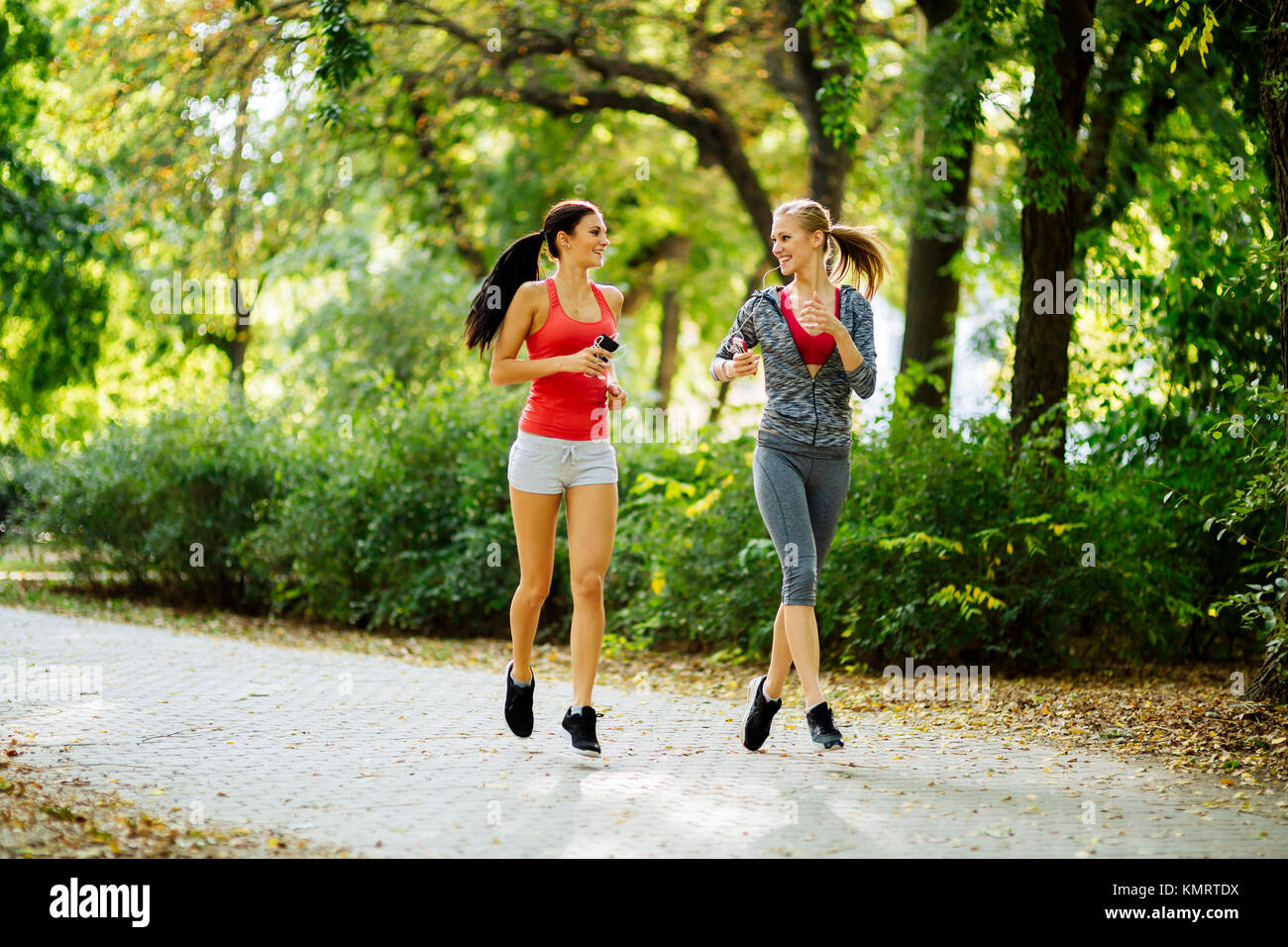 Energetic young women running outdoors Stock Photo - Alamy