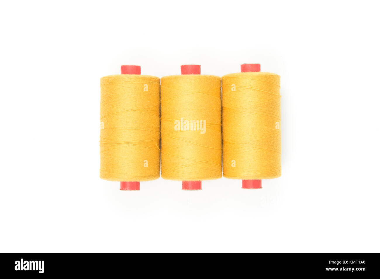 Yellow thread coils on white background, sewing and tailoring supplies ...