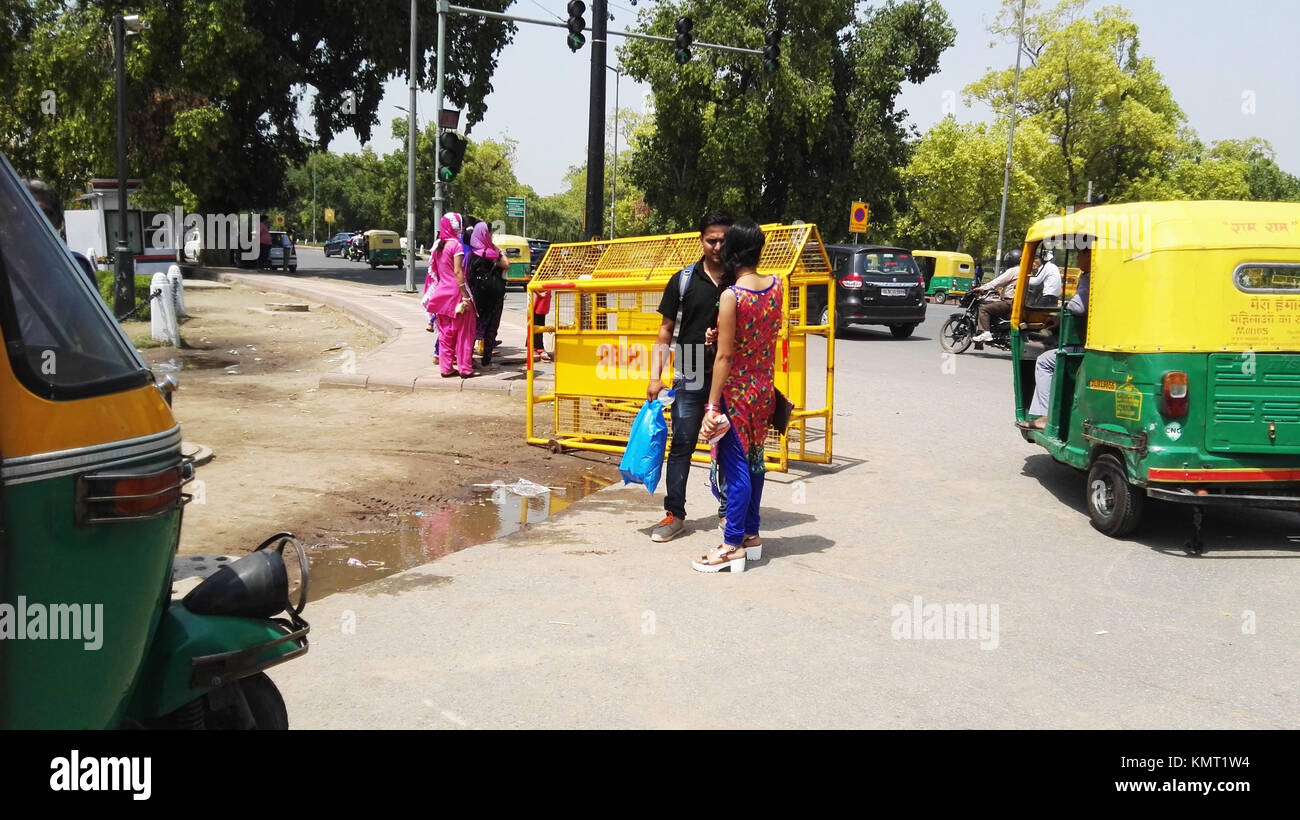Time to talk, two people having a conversation in a busy road in New Delhi India Stock Photo