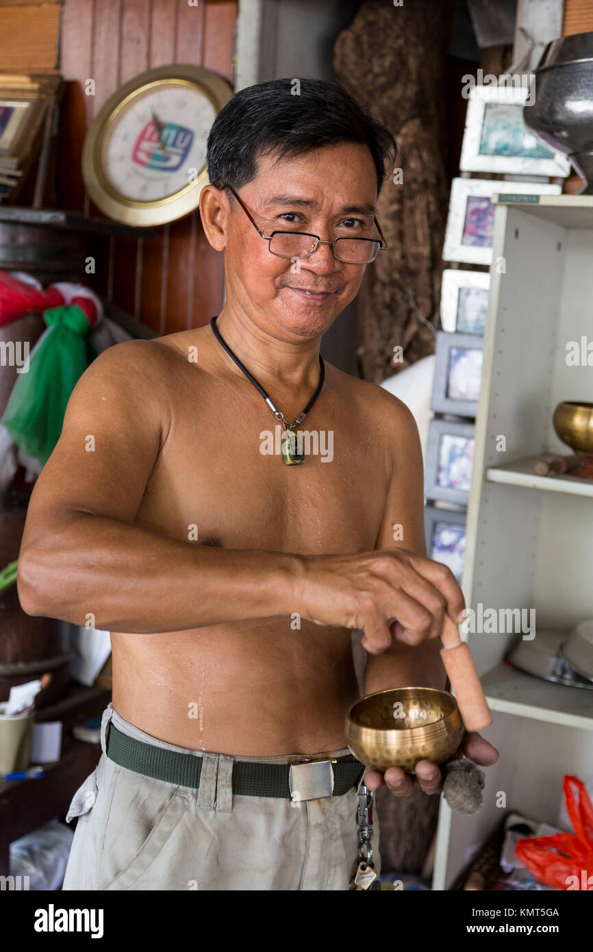 Bangkok, Thailand.  Craftsman Demonstrating a 'Singing Bowl.' Stock Photo