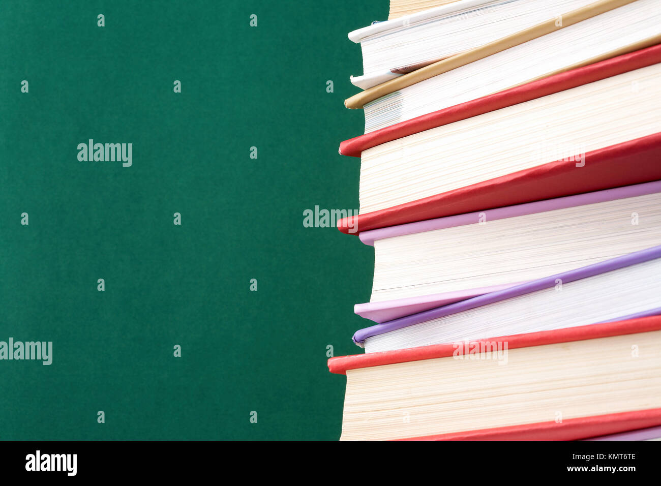Colorful stack of textbooks on background of blackboard Stock Photo - Alamy