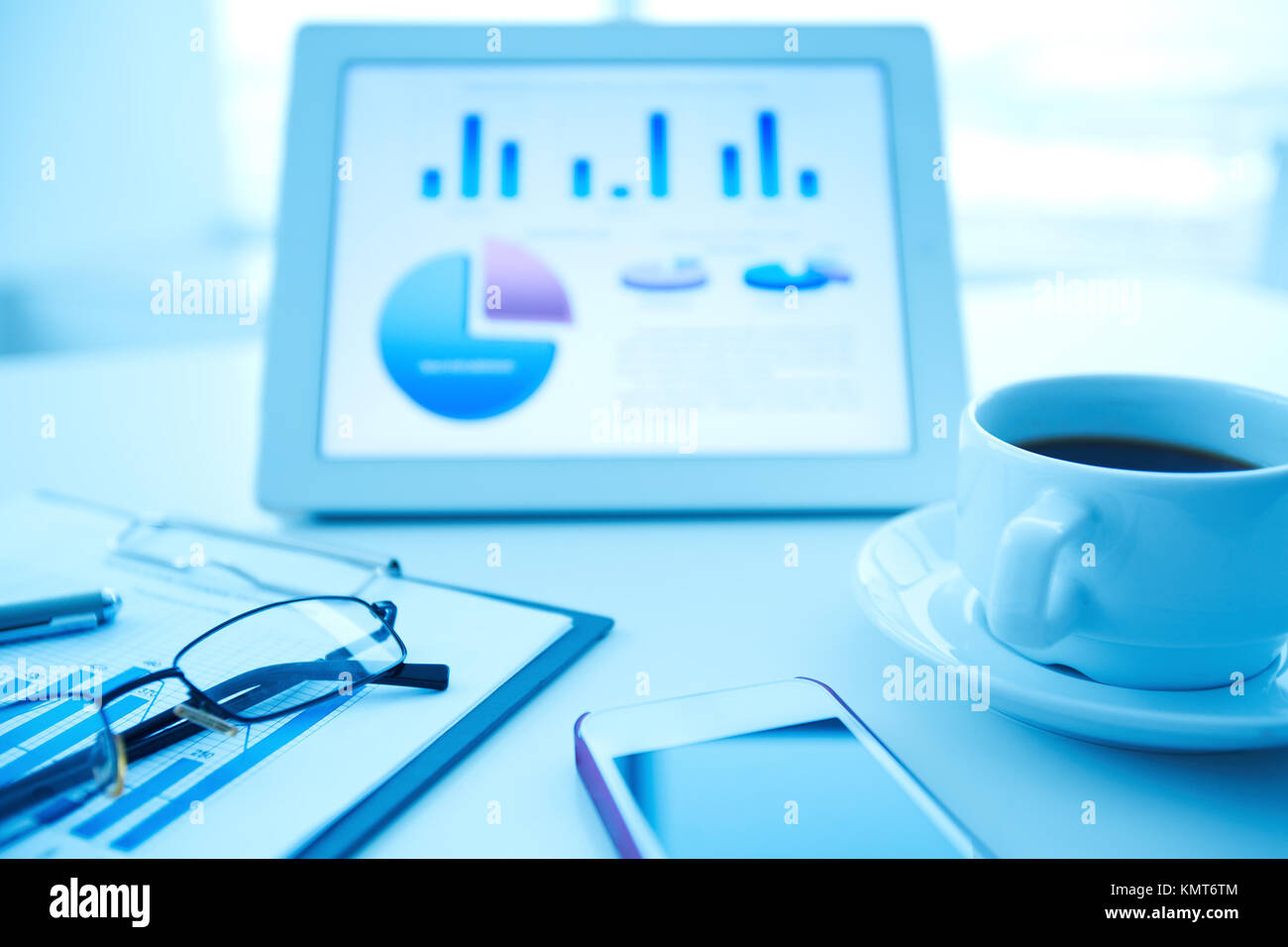 Image of an office workplace with paper, wireless gadgets and a cup of ...