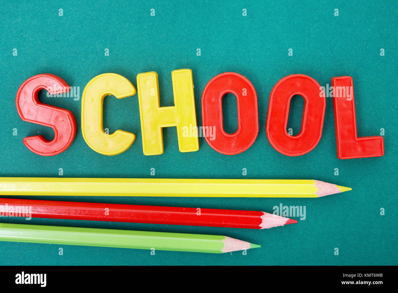 Image of word ‘school’ with three colorful pencils below Stock Photo