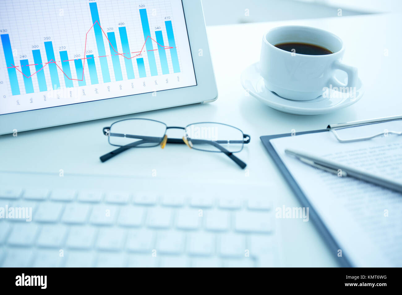 Image of workplace with electronic document, cup of coffee and eyeglasses on it Stock Photo