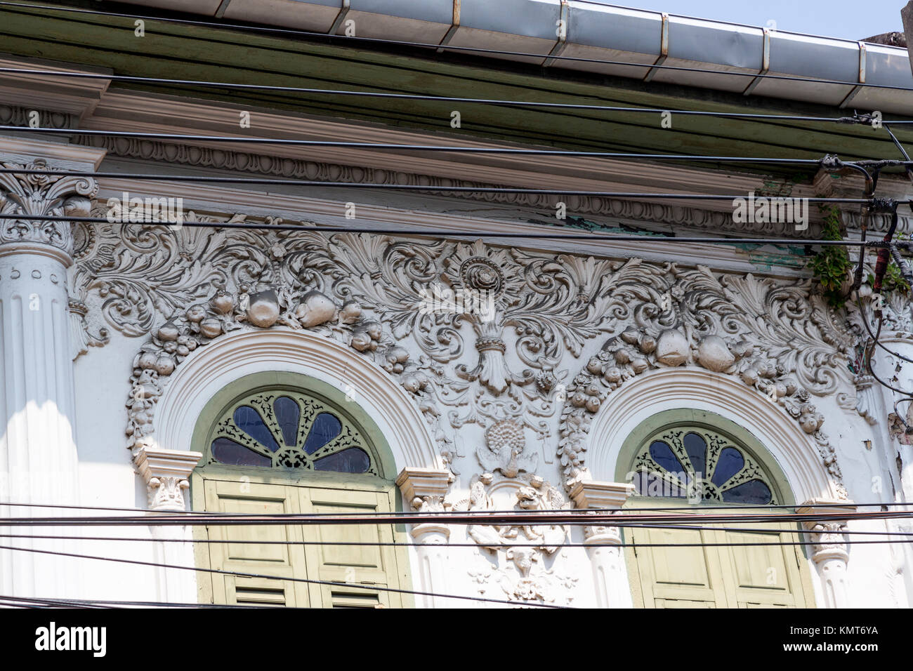 Bangkok, Thailand.  Coconut Decoration above Windows of Buildings formerly Serving as Offices for Fruit and Vegetable Import-Export Business. Stock Photo