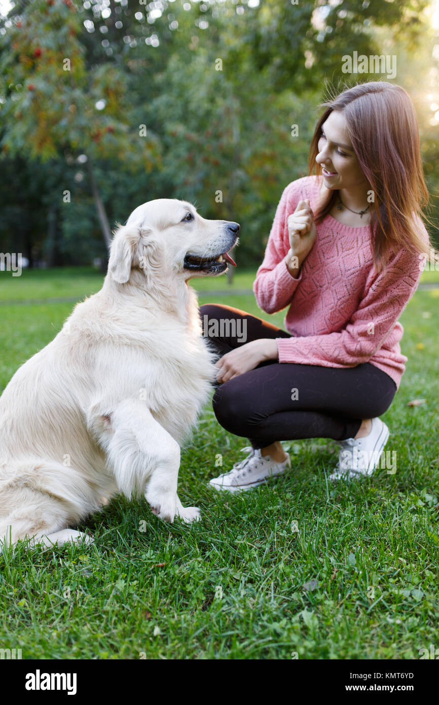 Picture of woman with dog on lawn in summer park Stock Photo - Alamy