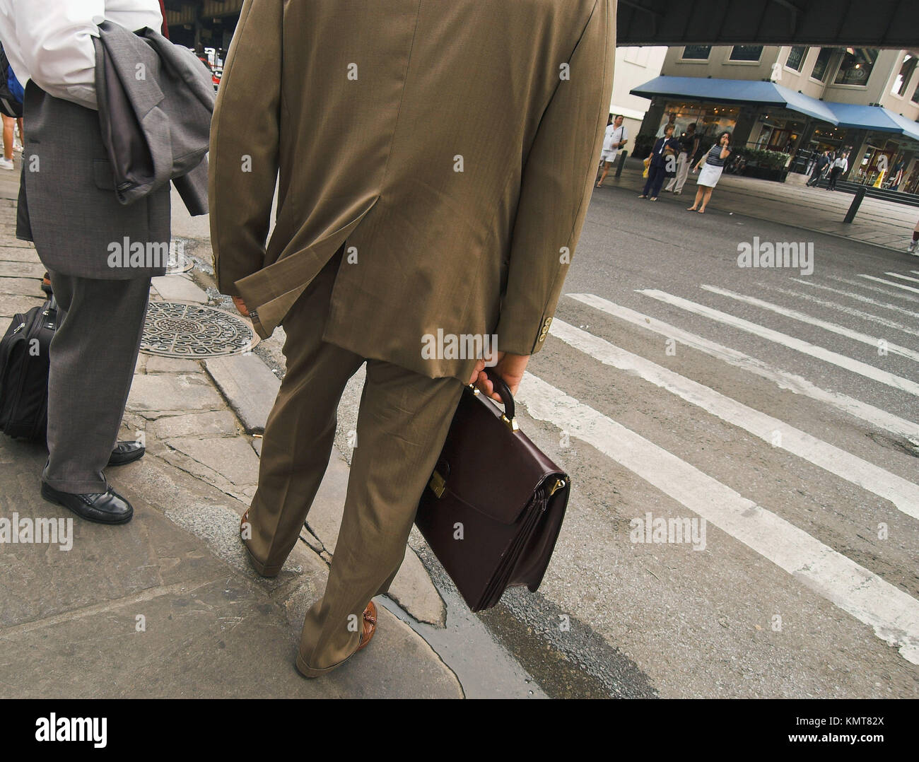 Businessmen with briefcases waiting to cross street. New York City. New
