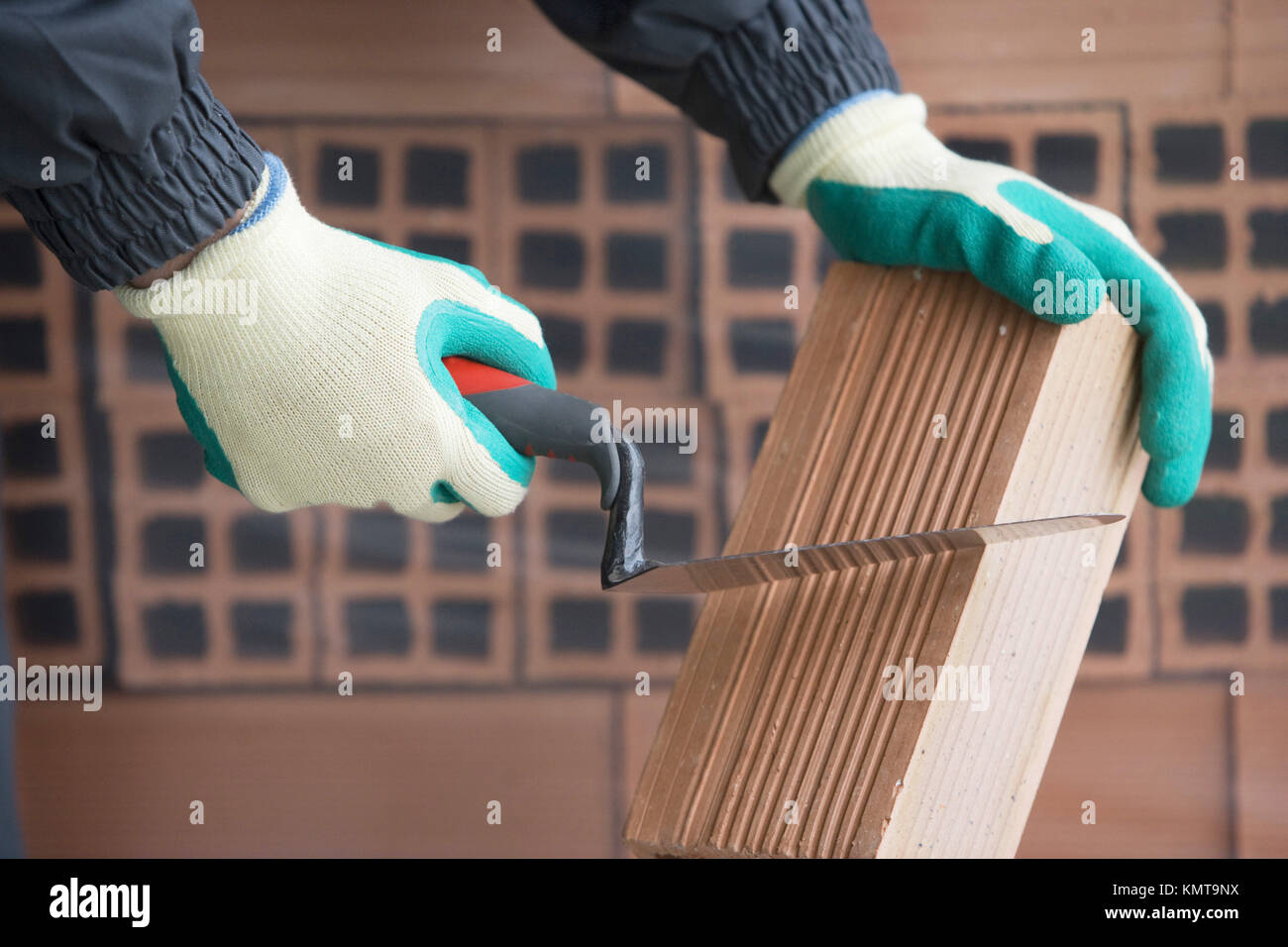 Cutting brick mason with trowel, housing construction Stock Photo