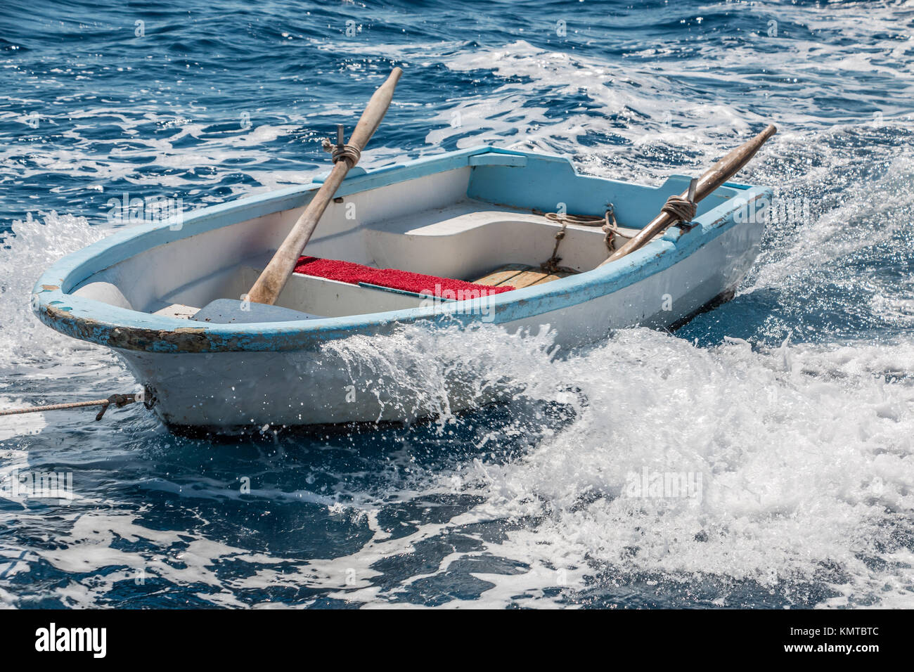 Lonely rowboat in the muddle of the endless sea Stock Photo