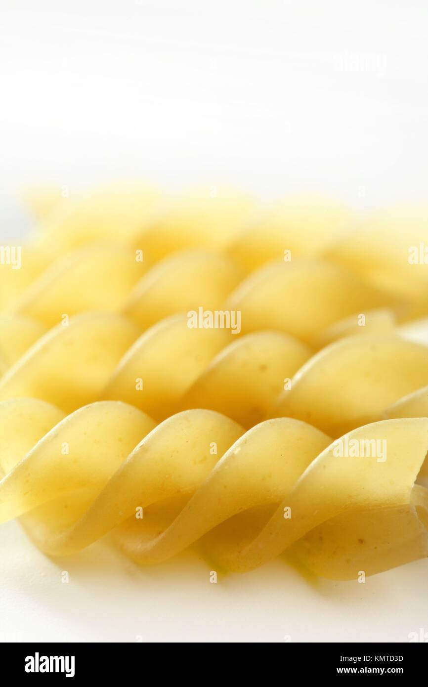Spiral fusilli dired pasta macro over white studio background Stock