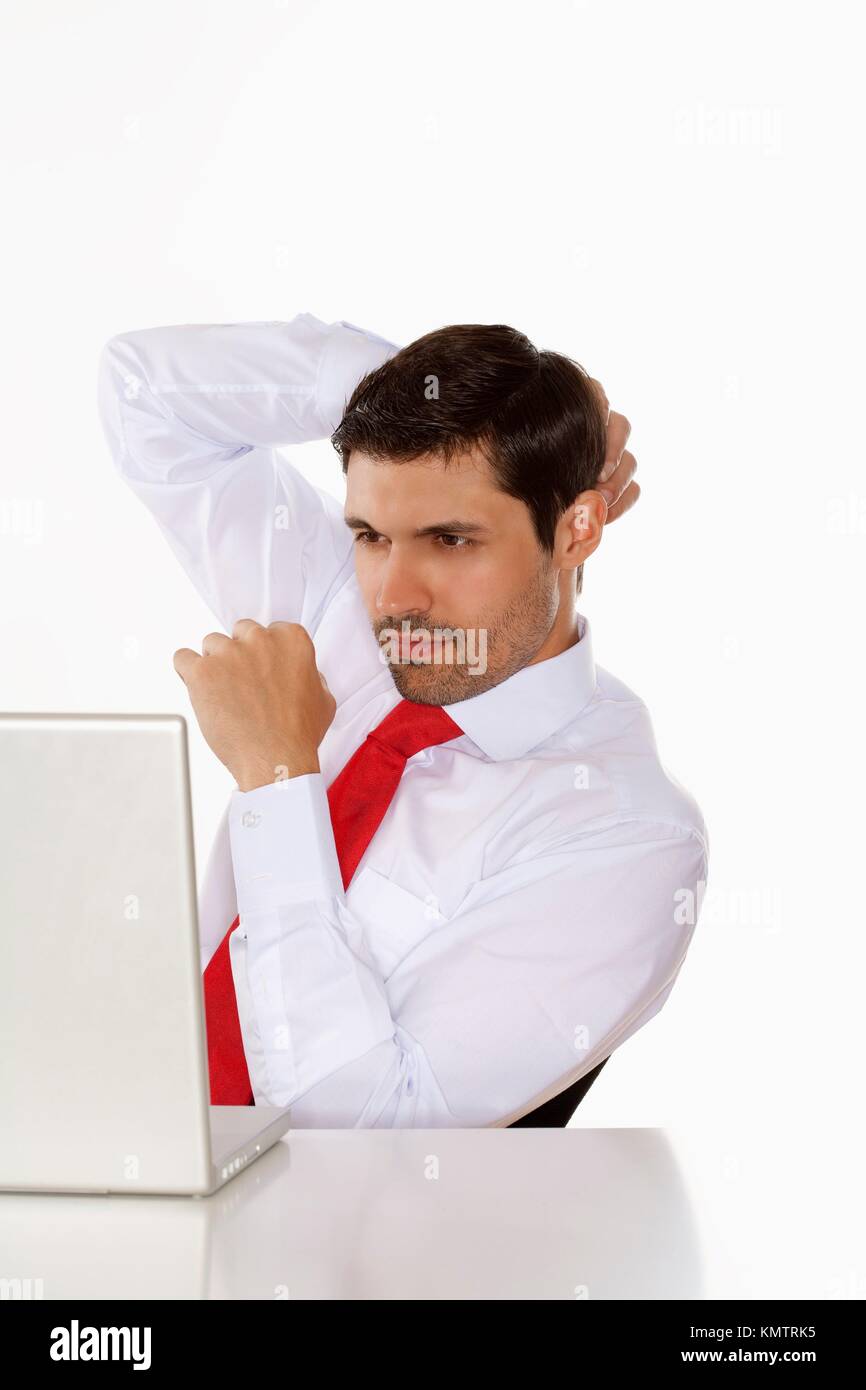 young business executive in white shirt behind desk with laptop Stock