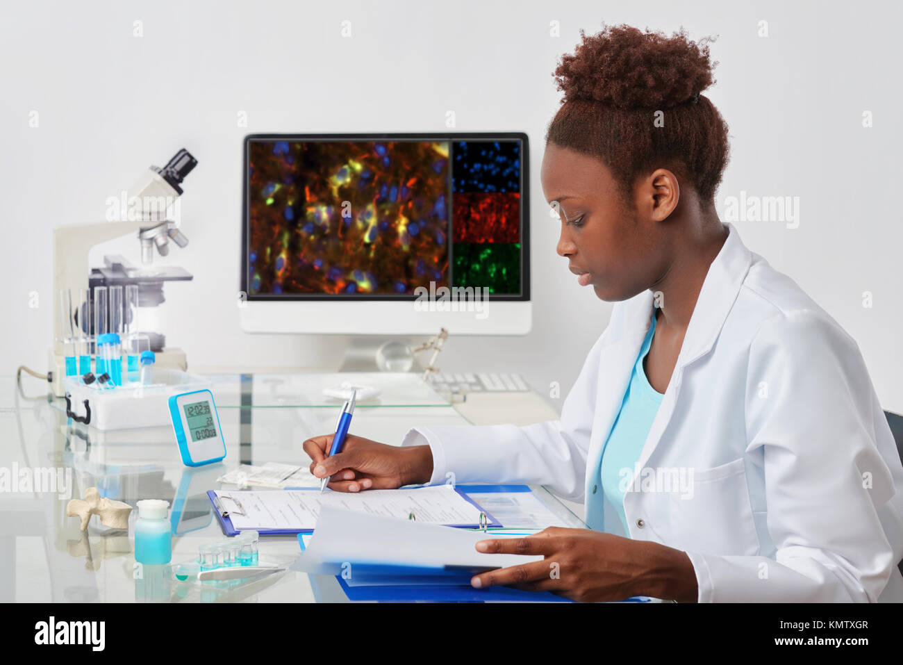 African-american biologist checks records in scientific lab or research facility. Focus on the face and eyelashes. Stock Photo