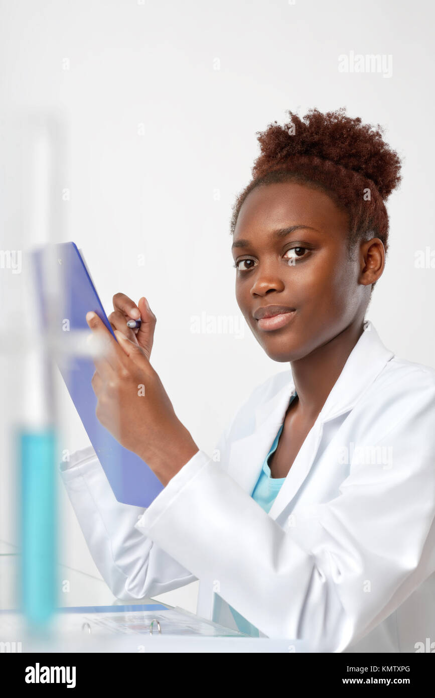 African biologist, medical student or doctor checks records, looking at the viewer. Studio shoot on neutral background Stock Photo