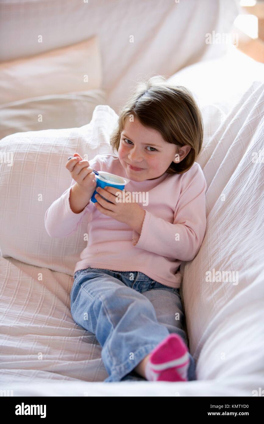 Caucasian girl eating yogurt at home Stock Photo Alamy