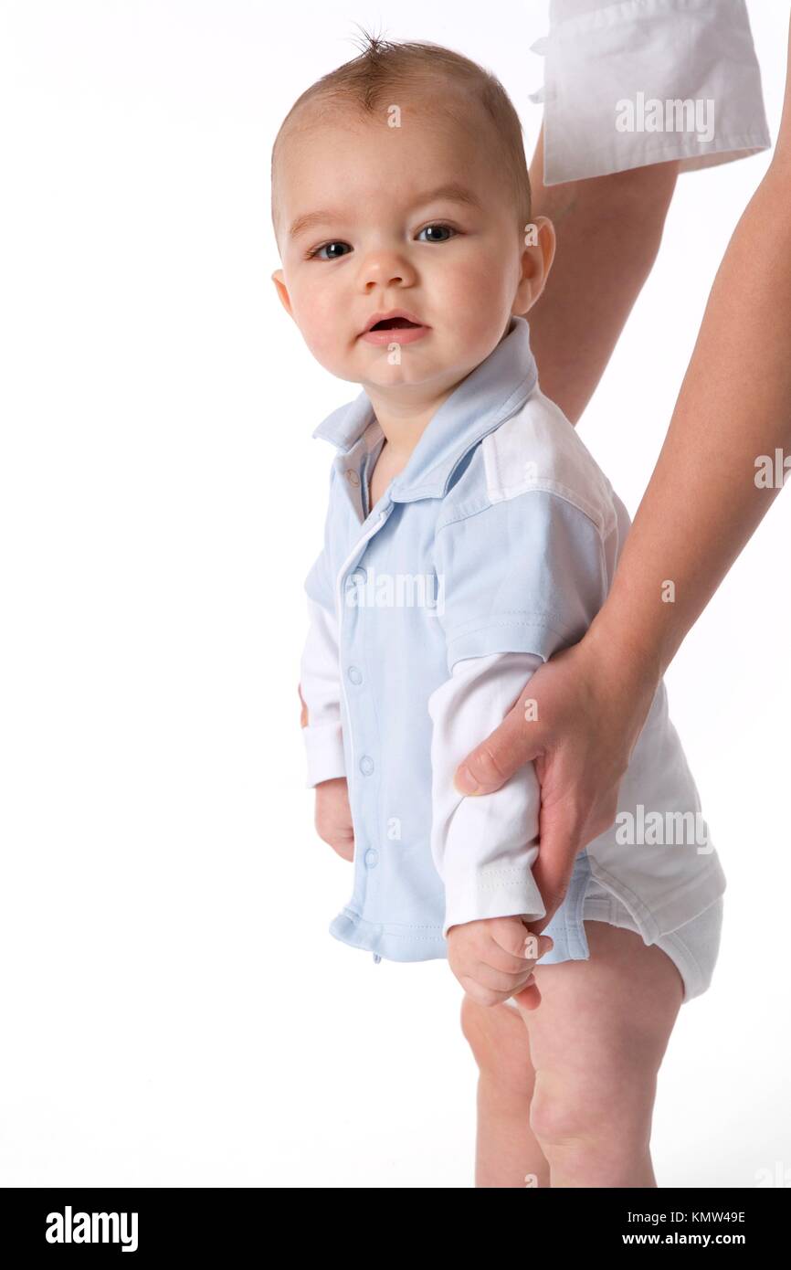 Baby Boy Is Standing On His Feet With Some Help Stock Photo Alamy