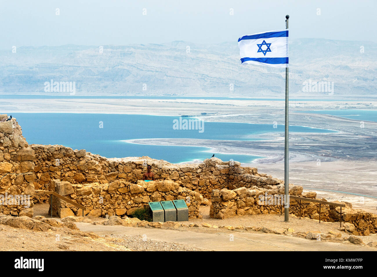 Aerial view on the Judaean Desert with the drying up Dead Sea from the Masada plateau with the flag of Israel and the ruins of the Herod palace Stock Photo
