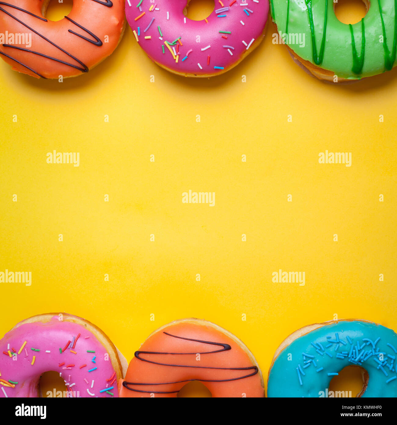 A set of sweet donuts on orange background. Top view with copy space ...