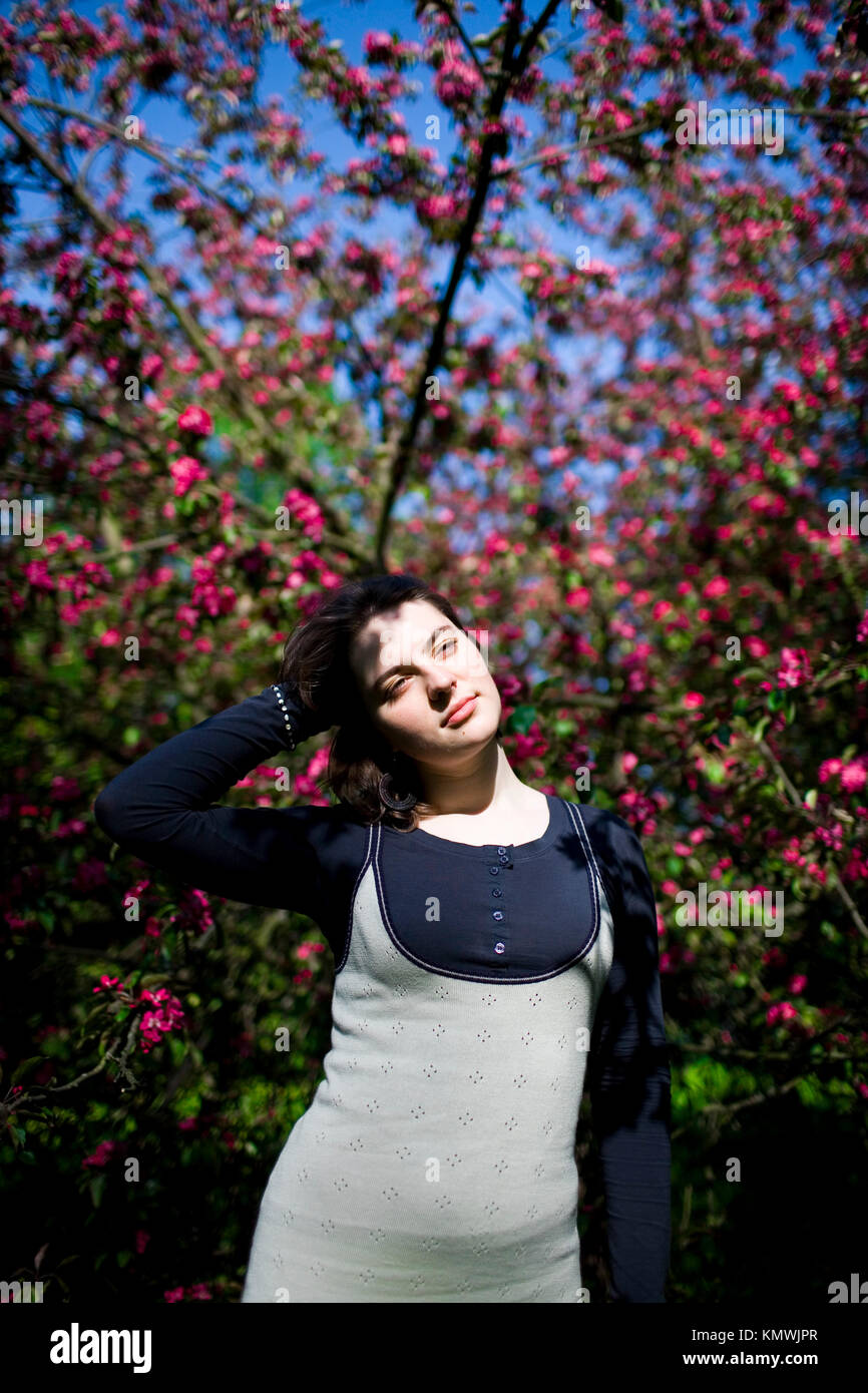 Portrait of a young beautiful girl in a flowering tree. Beauty of ...