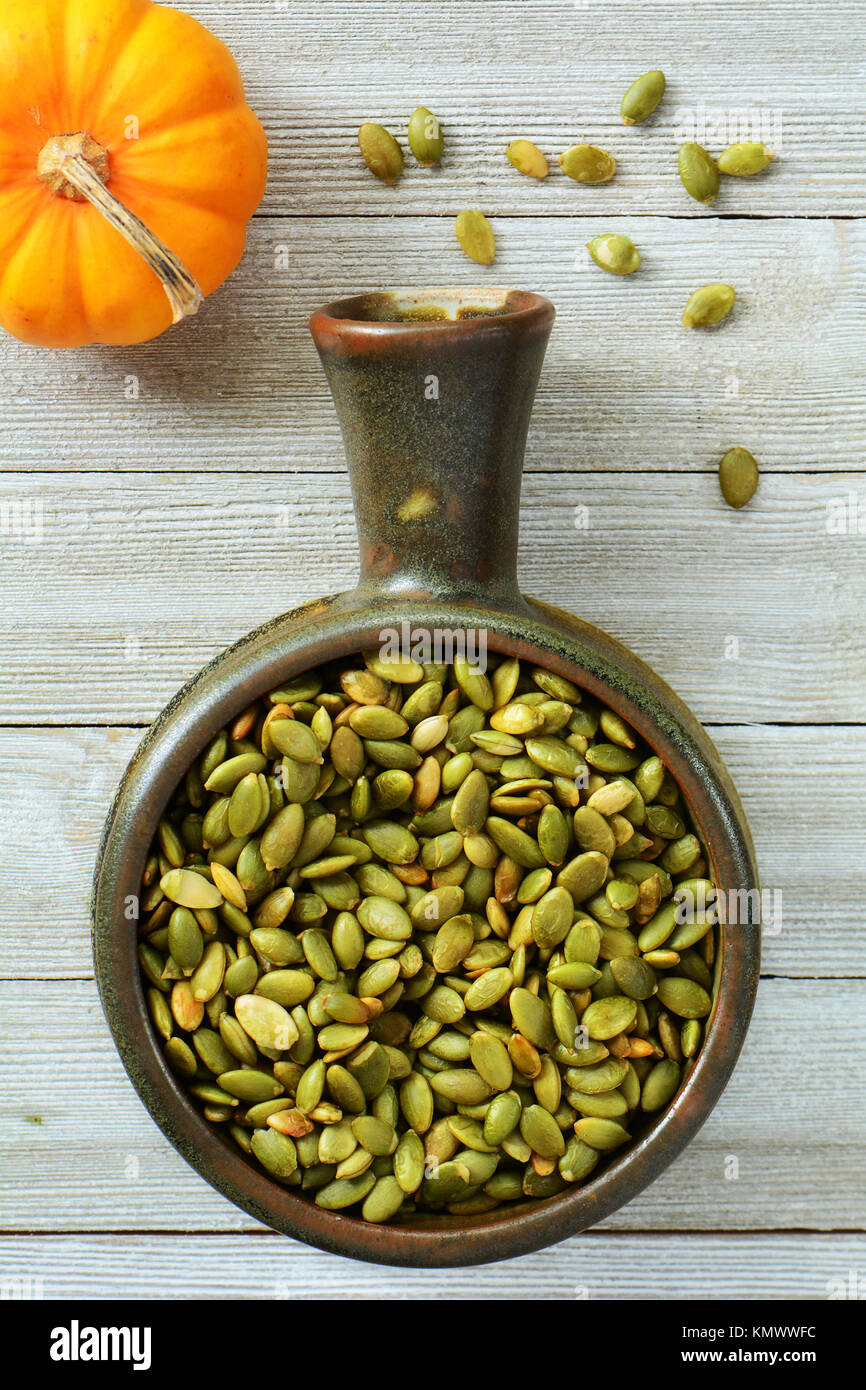 Download Raw Pumpkin Seeds In Earthenware Bowl And Miniature Pumpkin On Grey Stock Photo Alamy Yellowimages Mockups