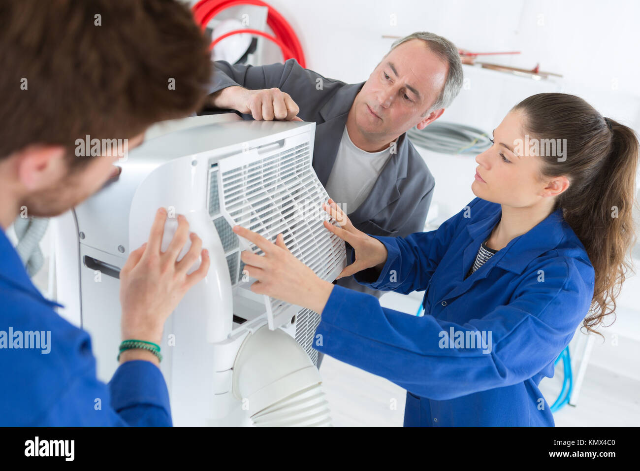 air conditioning repairman teaching students how to work Stock Photo