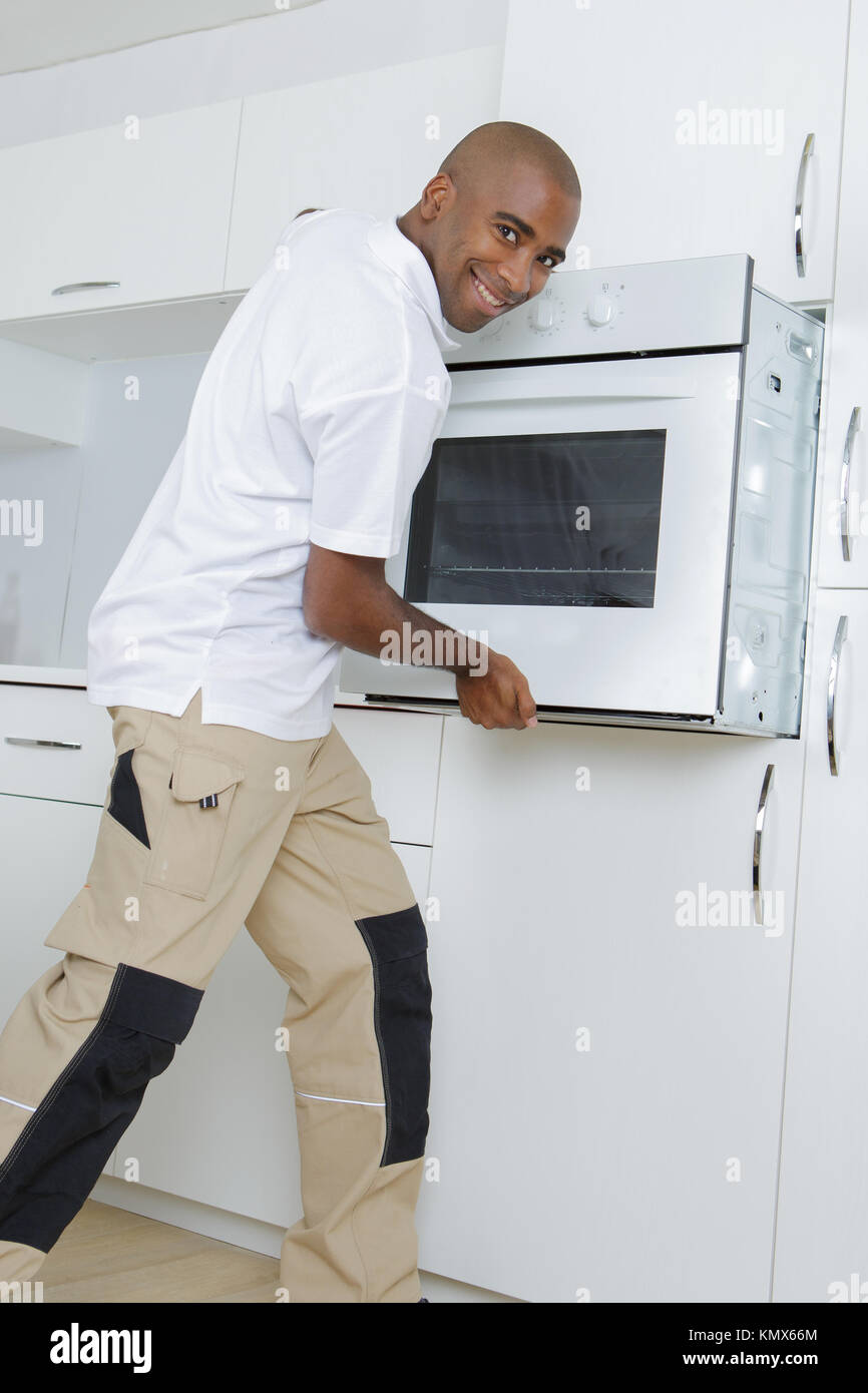Man fitting oven into kitchen Stock Photo Alamy