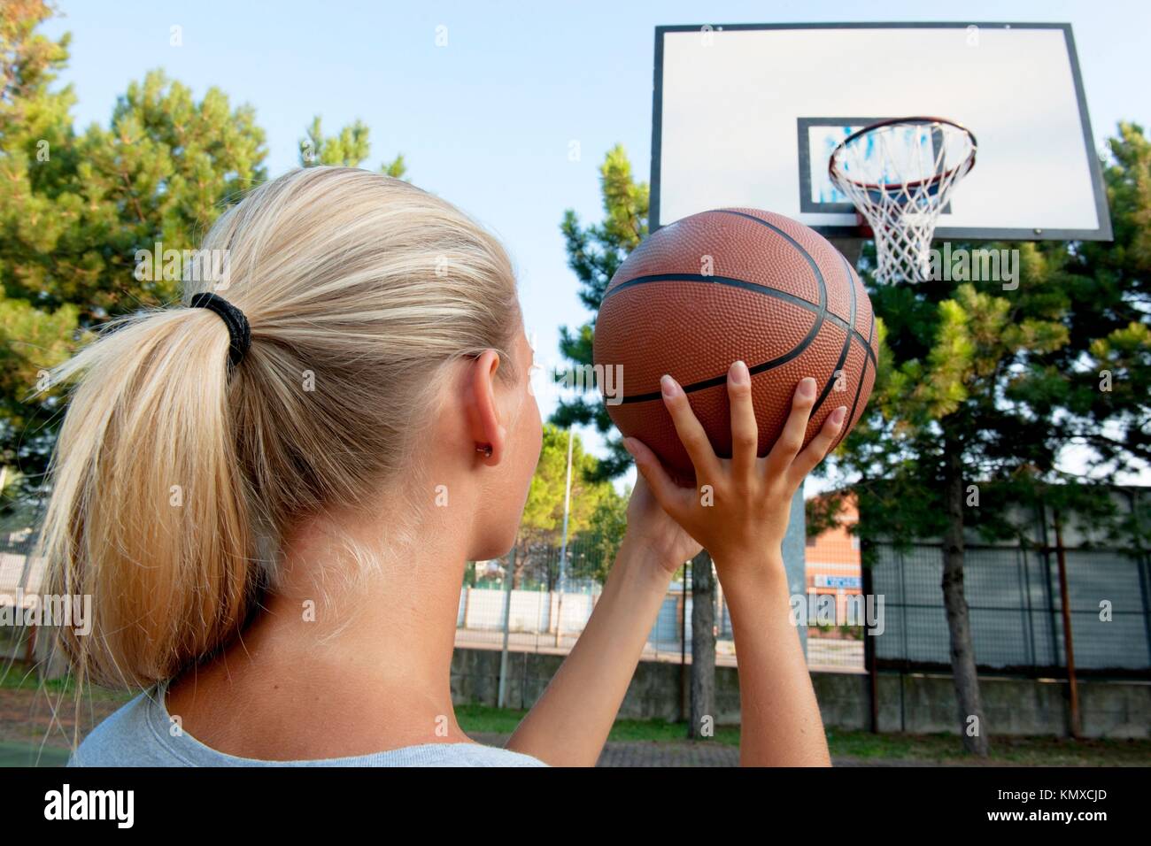 Young woman ready to throw basketball into loop Stock Photo Alamy